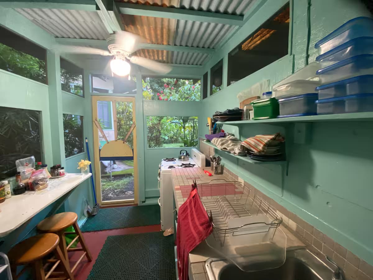 Shared kitchen space with gas stove, small fridge, and cooking essentials